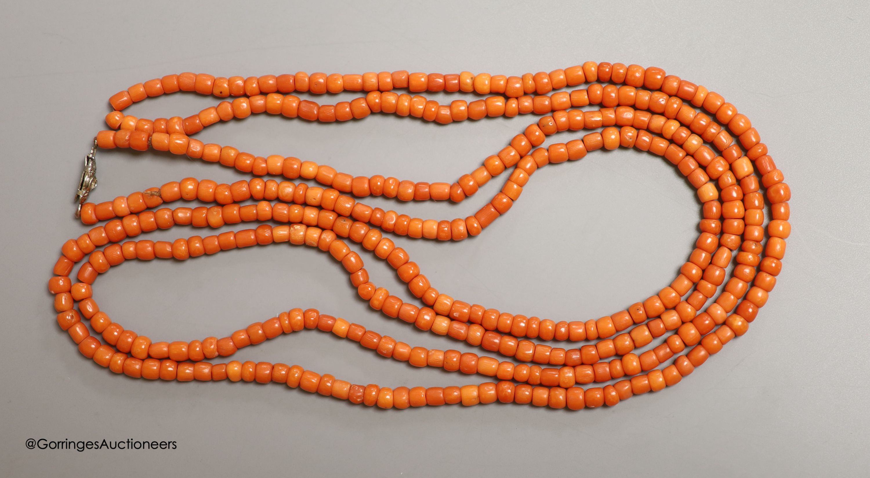 A long single strand coral bead necklace, with paste set clasp, 144cm, gross 55 grams.